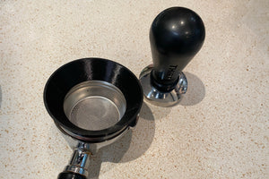 3D Printed dosing ring on a bottomless portafilter next to a THIRTY calibrated coffee tamp